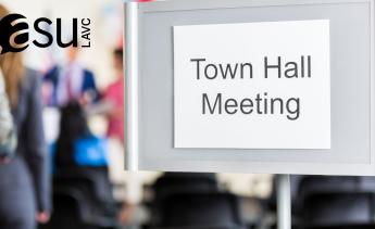 Sign outside of a meeting of blurred people that reads town hall