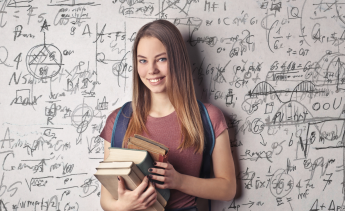 Girl with backpack and books in front a wall of math symbols