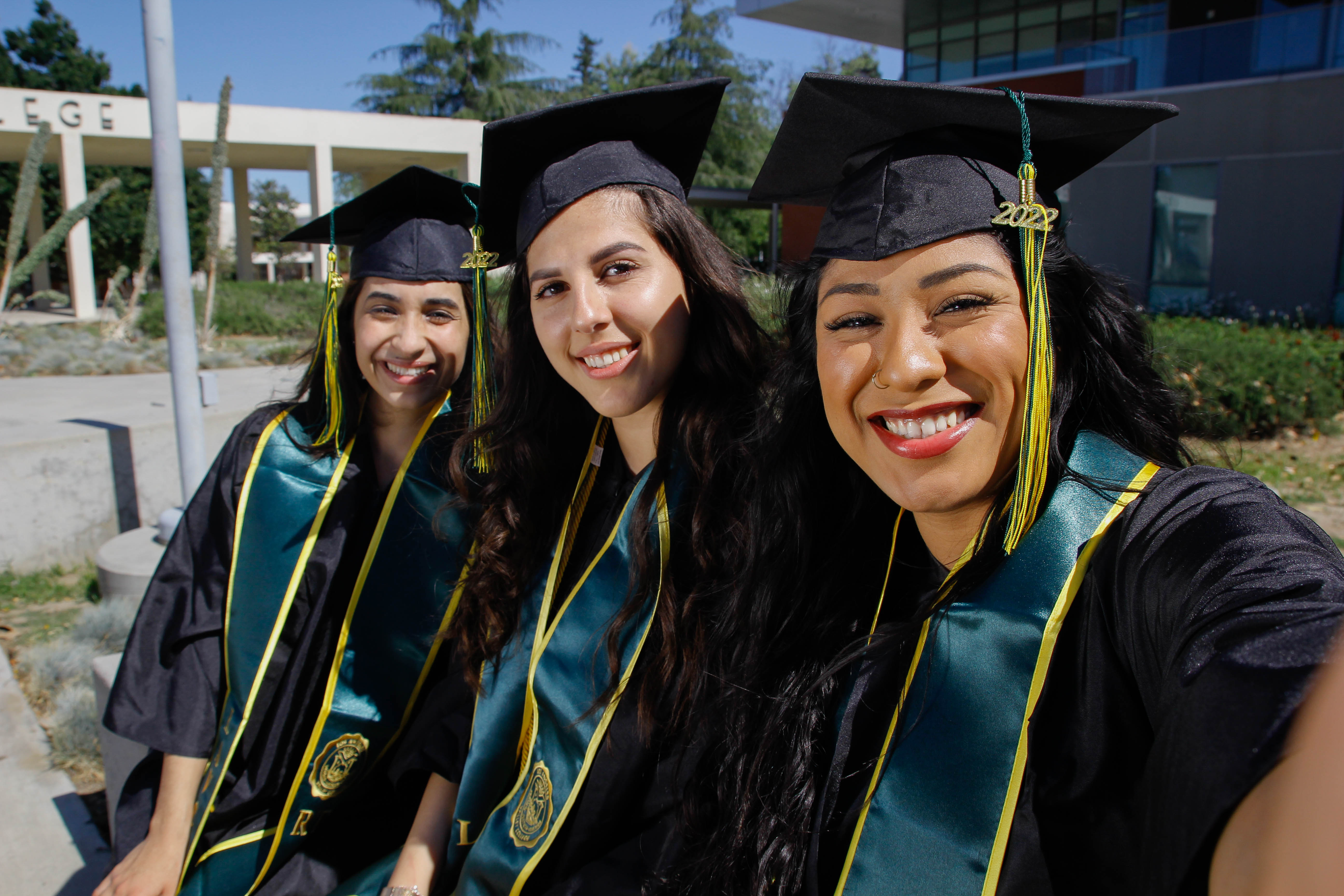 Three Student Girl at Graduation Smiling