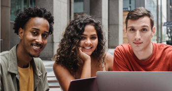 Diverse group of students in front of a laptop