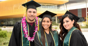 One male and two female LAVC graduates in front of the Student Union