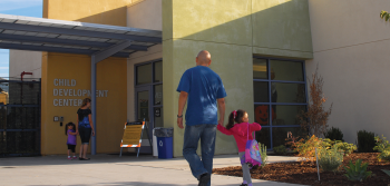 Parents walking children to Child Development Center in the Child Development and Family Complex