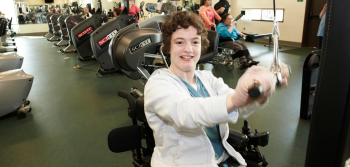 Student in wheelchair using the adapted gym equipment in the Adapted Physical Education Center