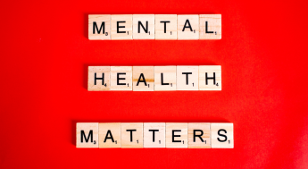 Wood square alphabet game pieces spelling out "Mental Health Matters"