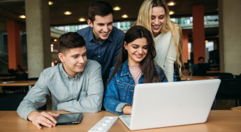 Group of students around a laptop to enroll online