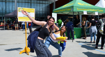 Two students happily posting in the Student Union Plaza 