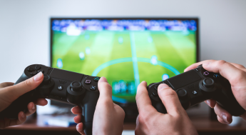 Two people with video game controllers playing a video game