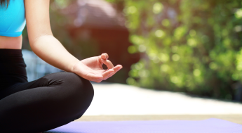 Person showing hand in yoga pose while outdoors