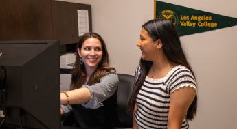 Counselor assisting student at a computer