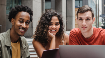 Diverse group of students in front of a laptop