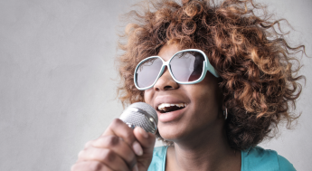 Black woman singing with microphone