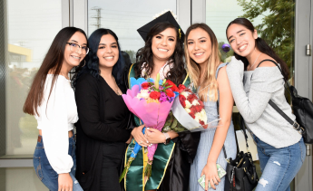 LAVC female graduate with female friends smiling at the camera