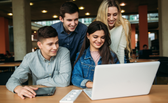 Group of students around a laptop to enroll online