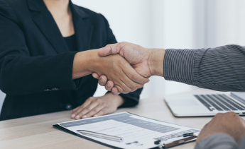 Job candidate shaking hands with employer at job interview