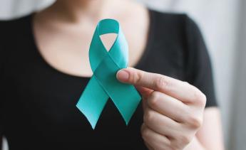 Person holding a teal ribbon