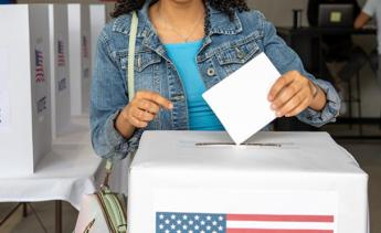 Female dropping ballot into voting ballot box