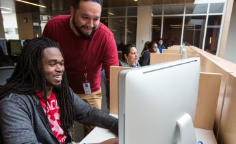 Staff assisting student with enrolling online