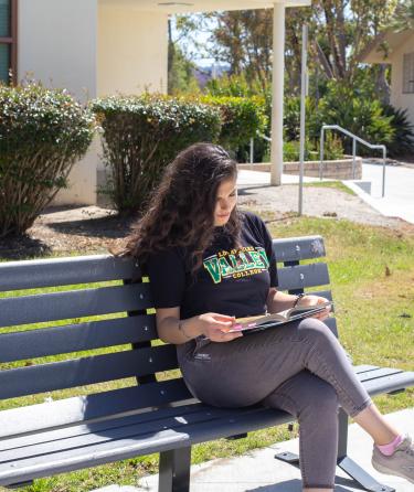 Girl Reading Seated on a Bench