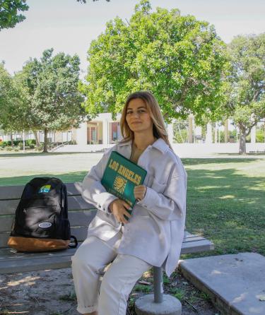 Student Seated Holding a Book