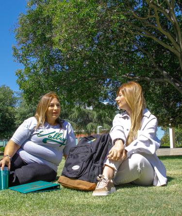 Two Students Seated on the Grass