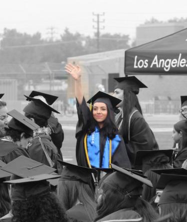 Student waving at graduation event.