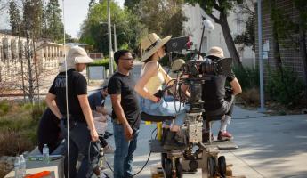 Students work the dolly as they get a tracking shot