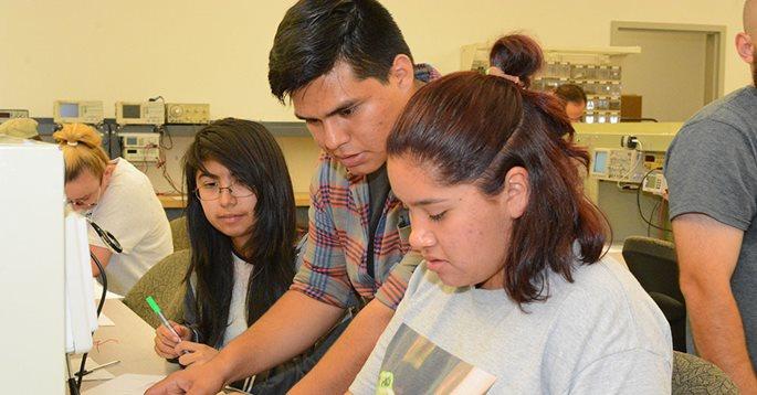 Three Students Looking at Their Work