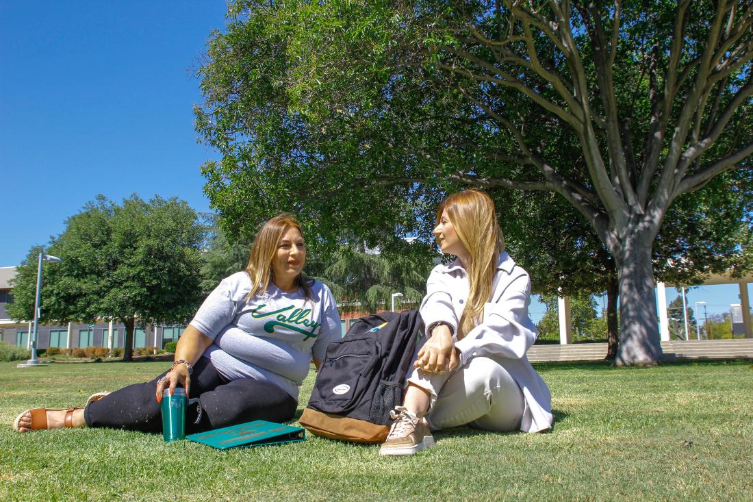 Two Students Seated on the Grass