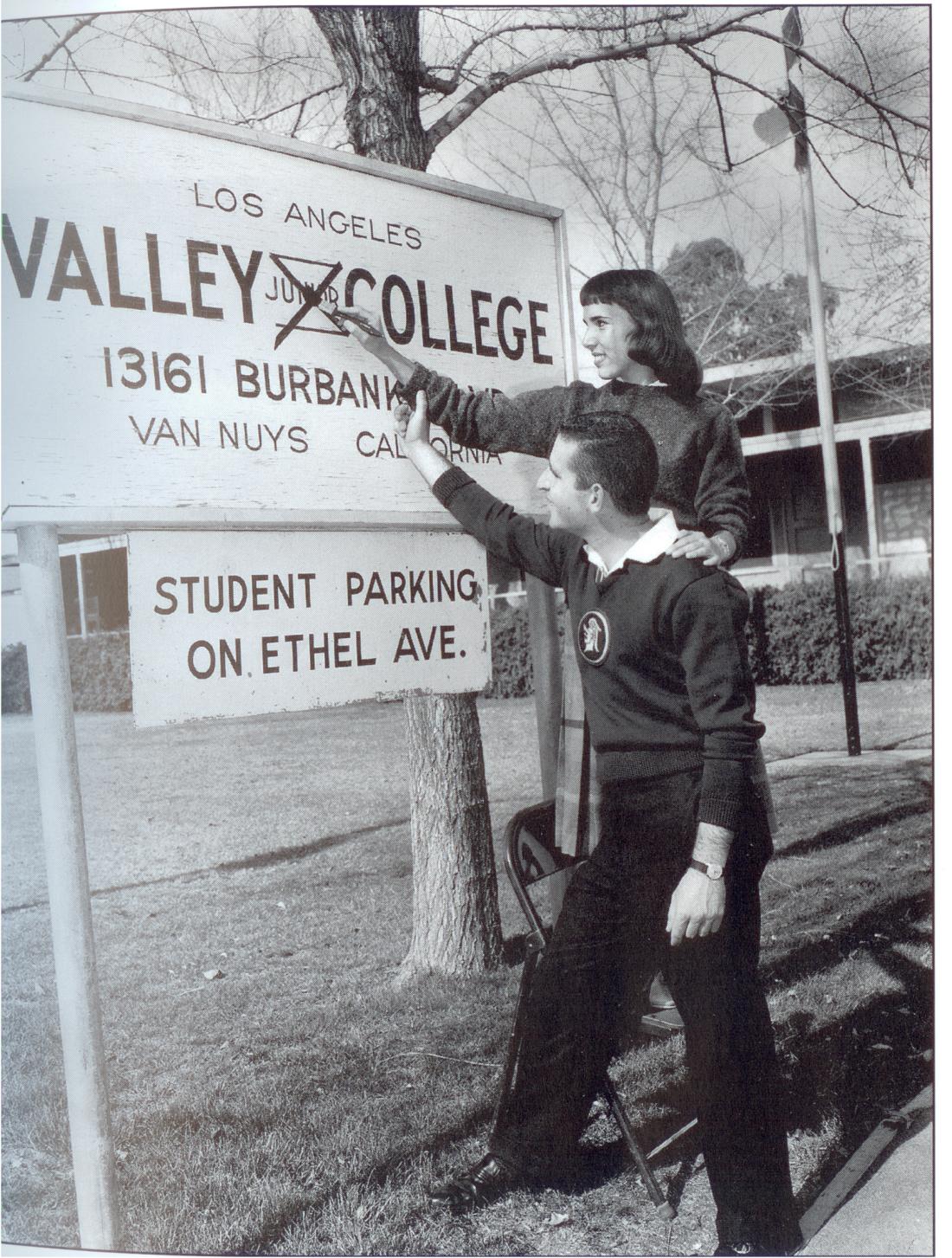 Female and male student in 1959 crossing out the word Junior in the Valley Junior College sign