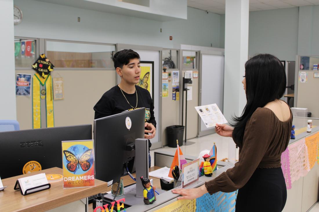 Two people discussing a flyer