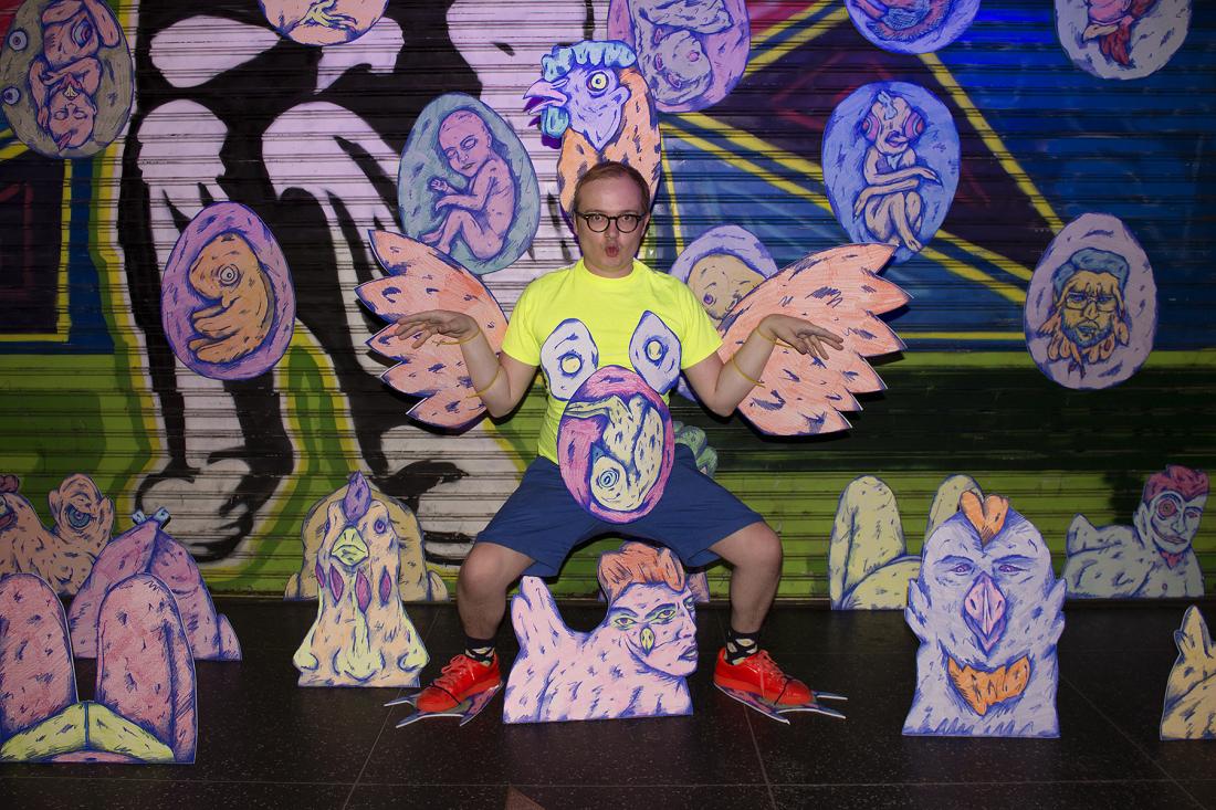 person in yellow shirt and blue shorts with cutout drawings around them