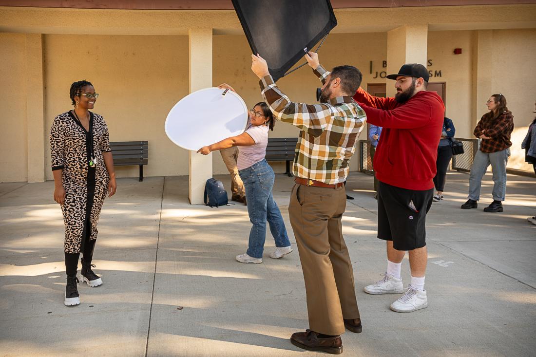 Photo students with instructor taking outside portrait. 