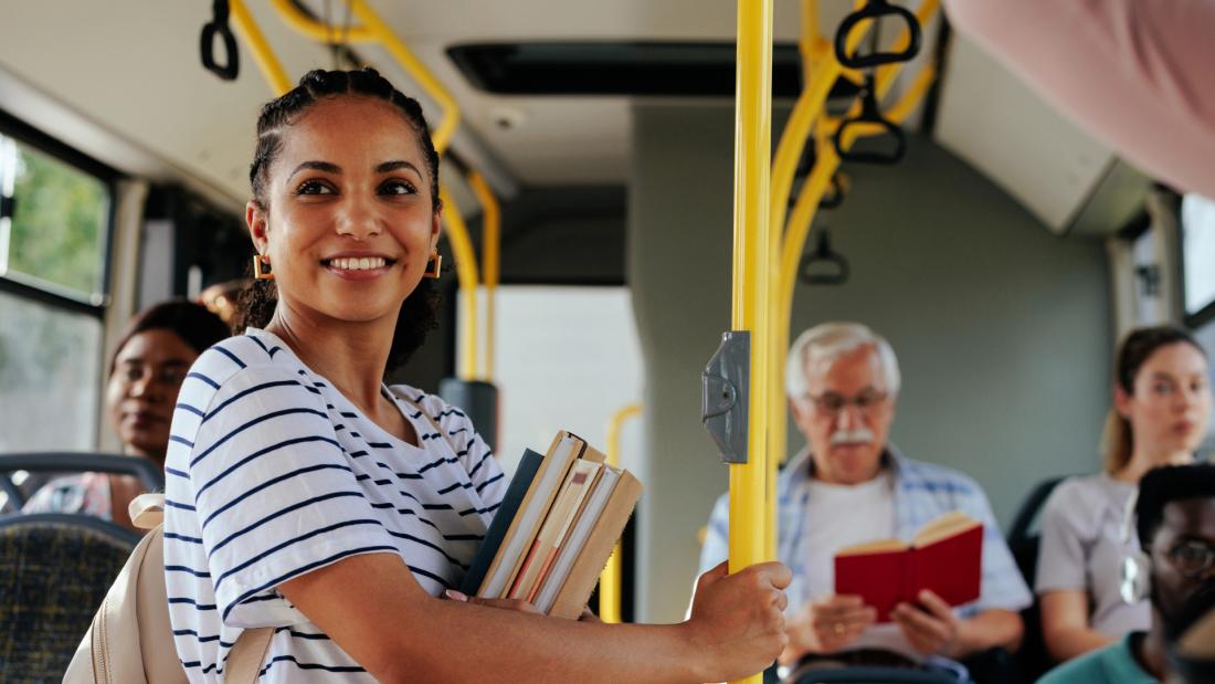 Female student holding books riding the bus