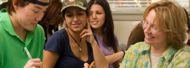 Female teacher in classroom answering student questions