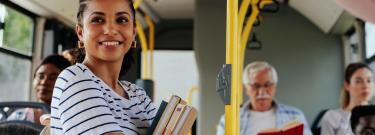 Female student holding books riding the bus