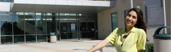 Female student in front of the Administration & Career Advancement building