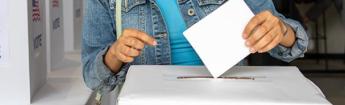 A woman casting her ballot into a ballot box