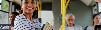 Female student holding books riding the bus