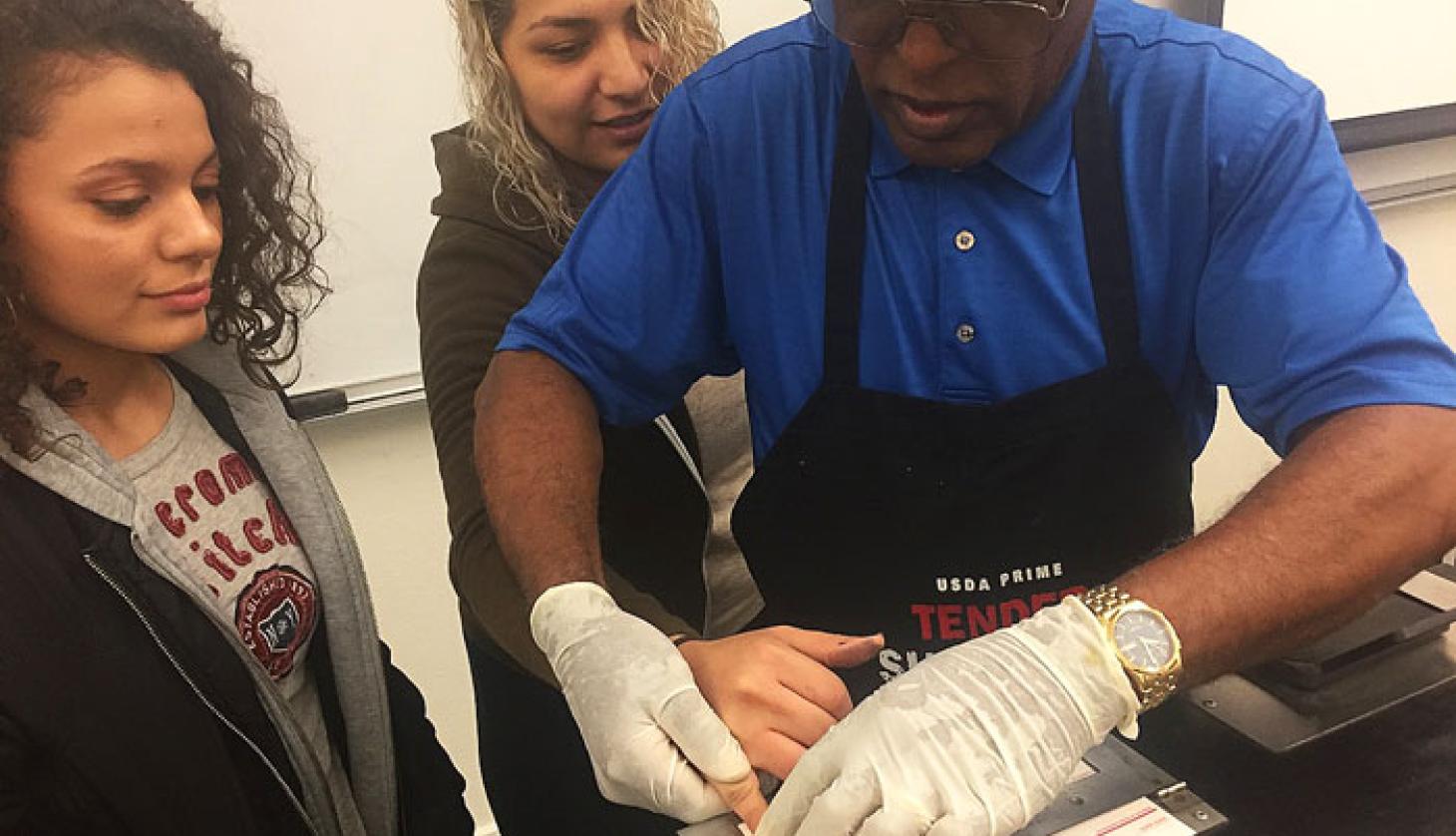 Teacher Making an Example About Finger Prints