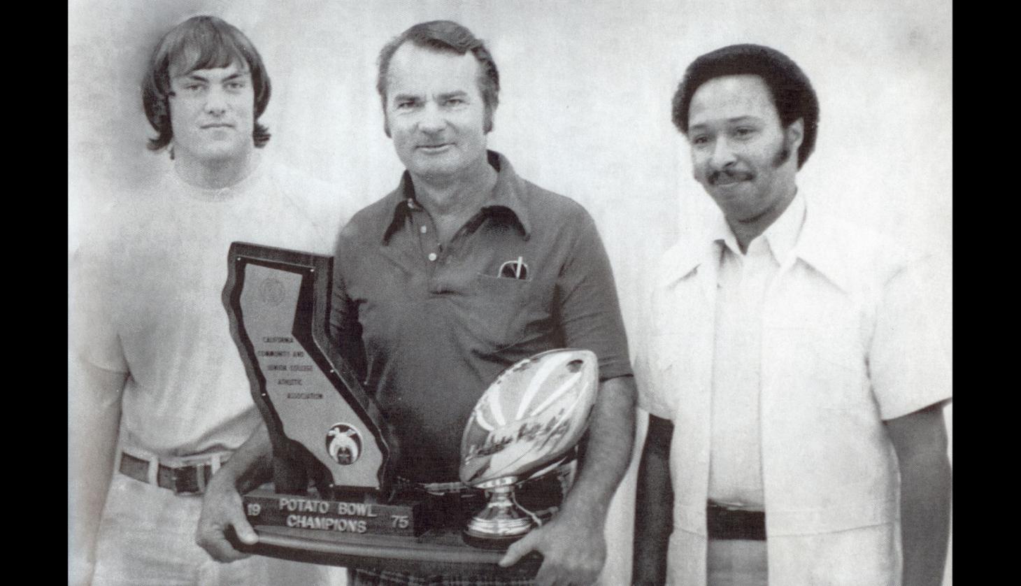 George Golf holding the 1975 Potato Bowl trophy